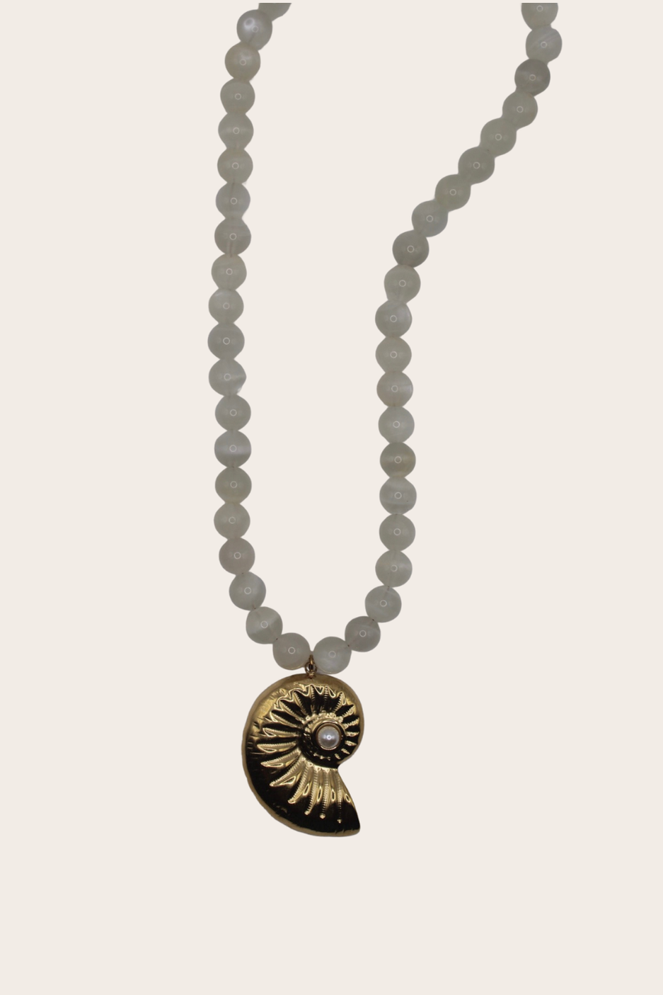 Marella Chain featuring white beads and a dark spiral shell pendant