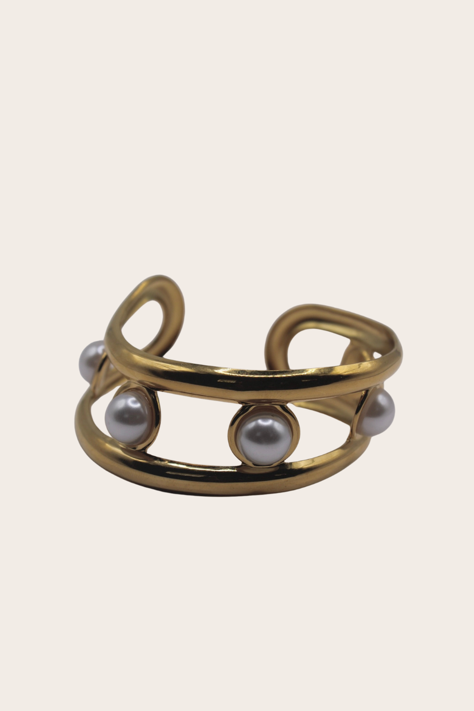 Golden Pearls Cuff featuring an open cuff with pearl-style accents and a flowing layered design