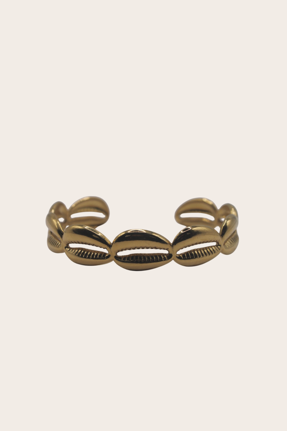 Golden Cowries Cuff featuring a polished cuff with repeating cowrie shell motifs